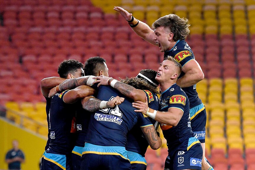 Gold Coast Titans NRL players celebrate the winning try against Wests Tigers.