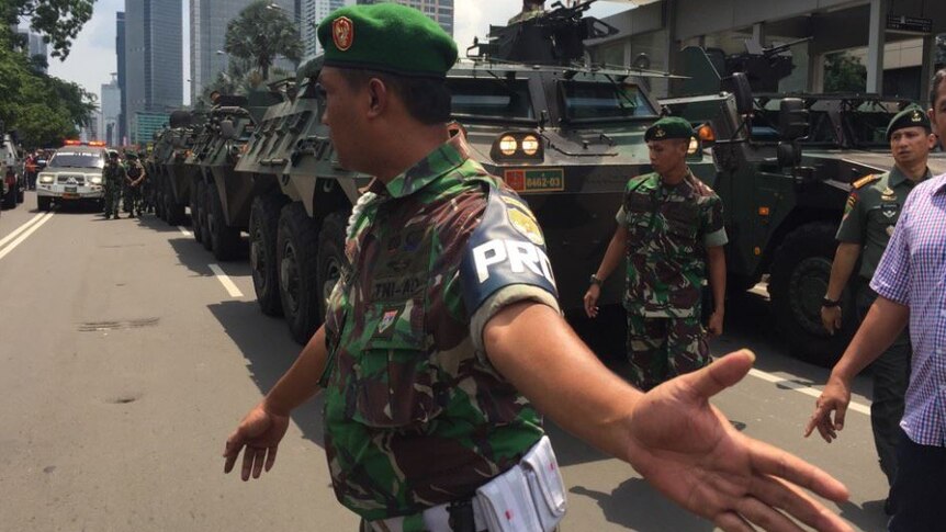 Police move back crowd as Armoured personnel carriers come through Jakarta, Indonesia after series of explosions