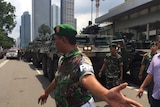 Police move back crowd as Armoured personnel carriers come through Jakarta, Indonesia after series of explosions