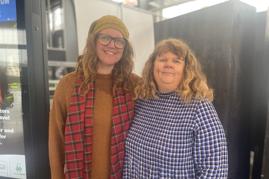 Two women smile at the camera.