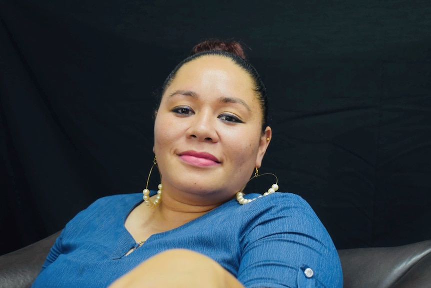 A woman wearing a blue blouse smiling 