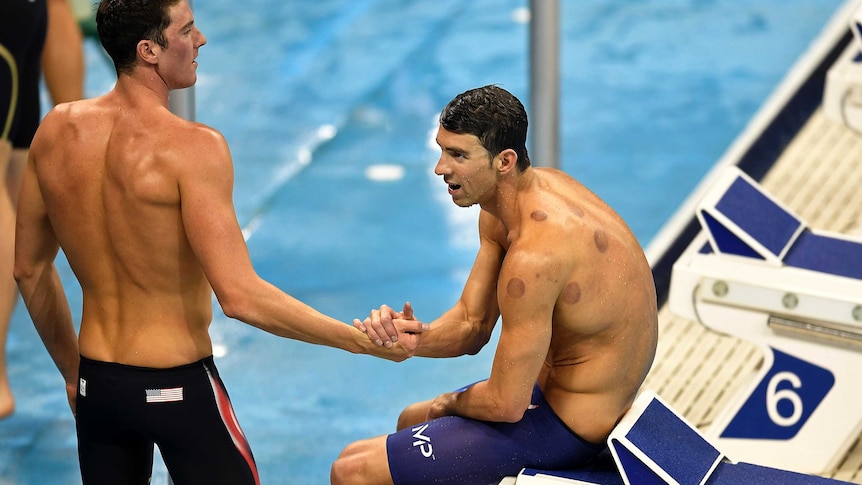 Michael Phelps slumps on the blocks after the 4x200m freestyle relay