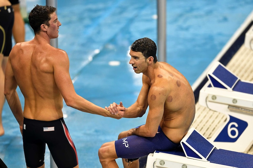 Michael Phelps slumps on the blocks after the 4x200m freestyle relay