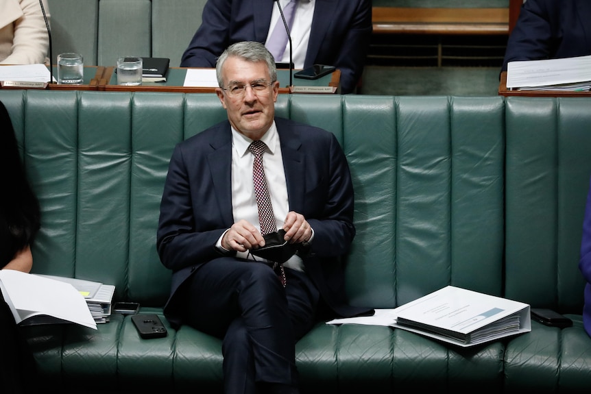 Mark Dreyfus sits on the frontbench holding a face mask in the House of Representatives