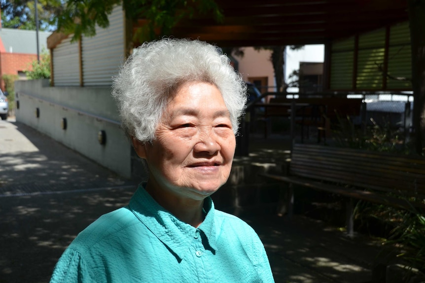 A side profile of a lady with white hair, she looks into the distance.