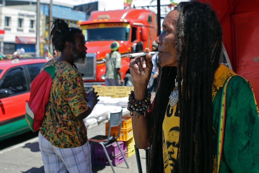 A demonstrator smokes marijuana during a pro-legalisation march in Jamaica