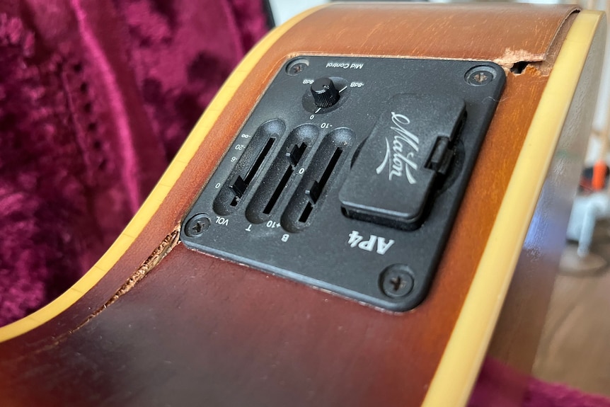 close up of electronic control of an acoustic guitar cracked around the edges