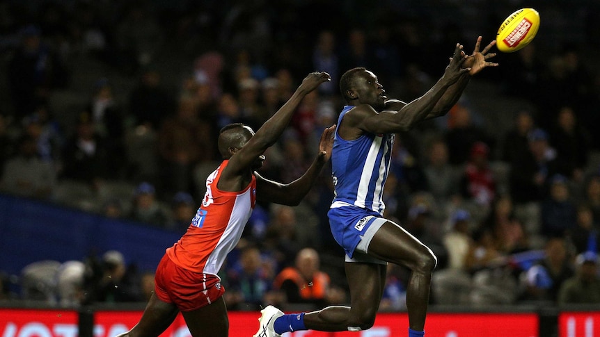 Majak Daw marks in front of Aliir Aliir during the North Melboure versus Sydney match.