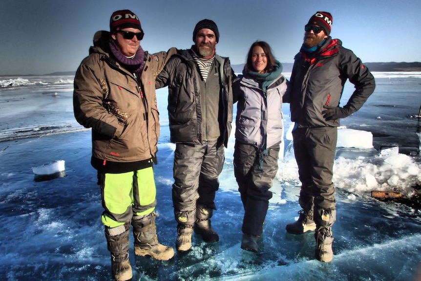 Four friends from Darwin stand on a lake in Siberia.