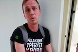 Ivan Golunov, wearing casual clothes, looks distressed as he looks towards the camera
