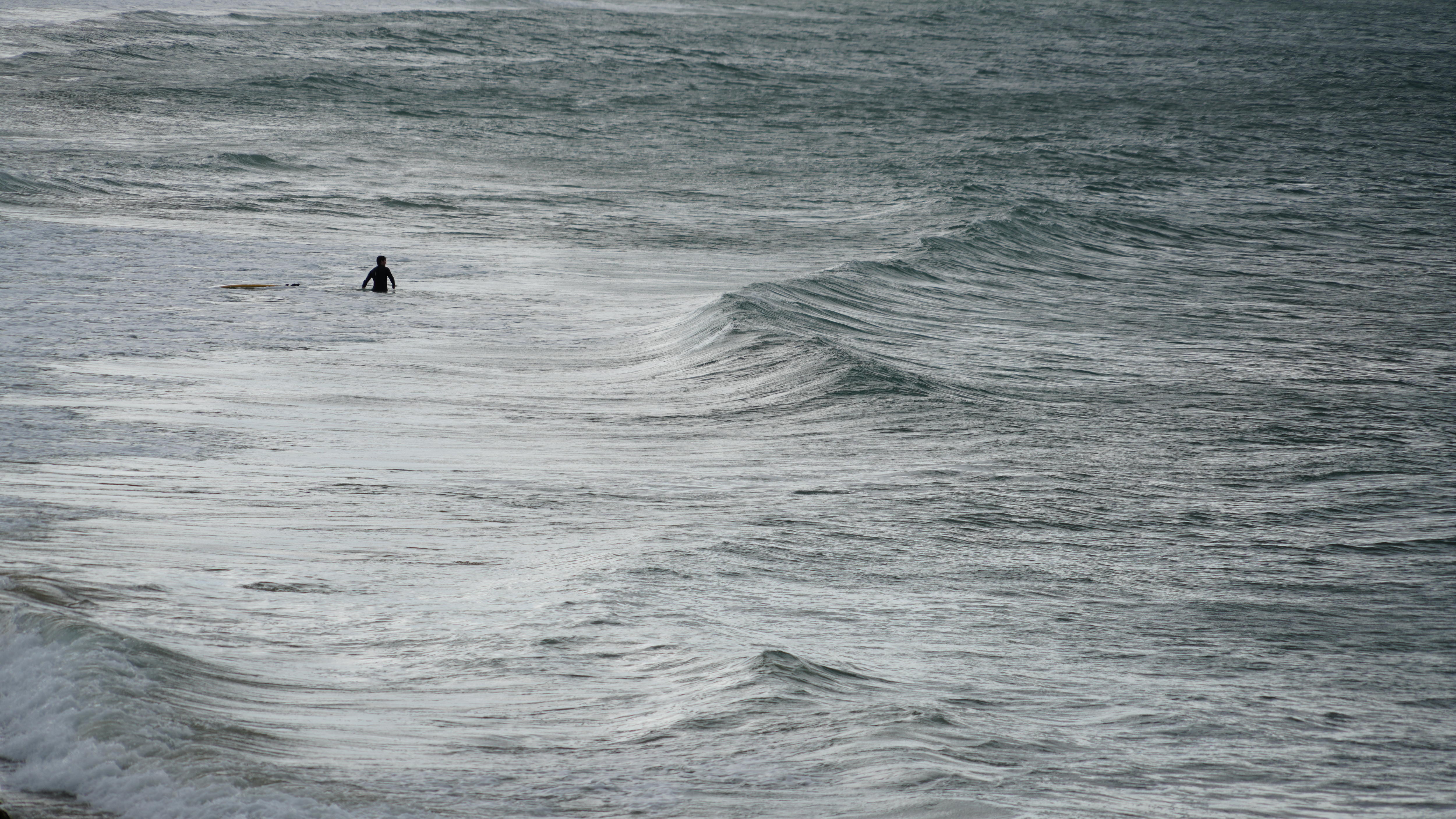 Man in ocean with surfboard
