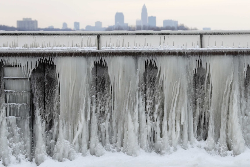 Ice forms on a breakwall along Lake Erie with the city of Cleveland in the background