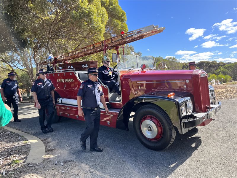 vintage red fire truck with four men walking