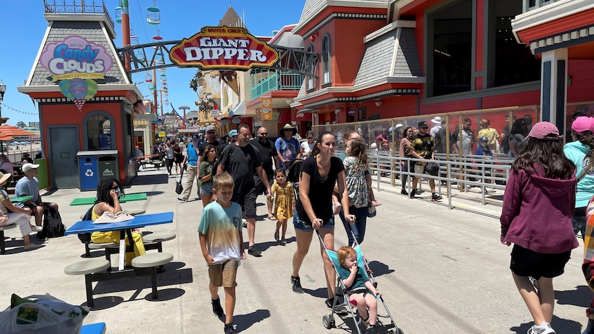 People walk past the Giant Dipper rollercoaster ride at the Santa Cruz Beach Boardwalk