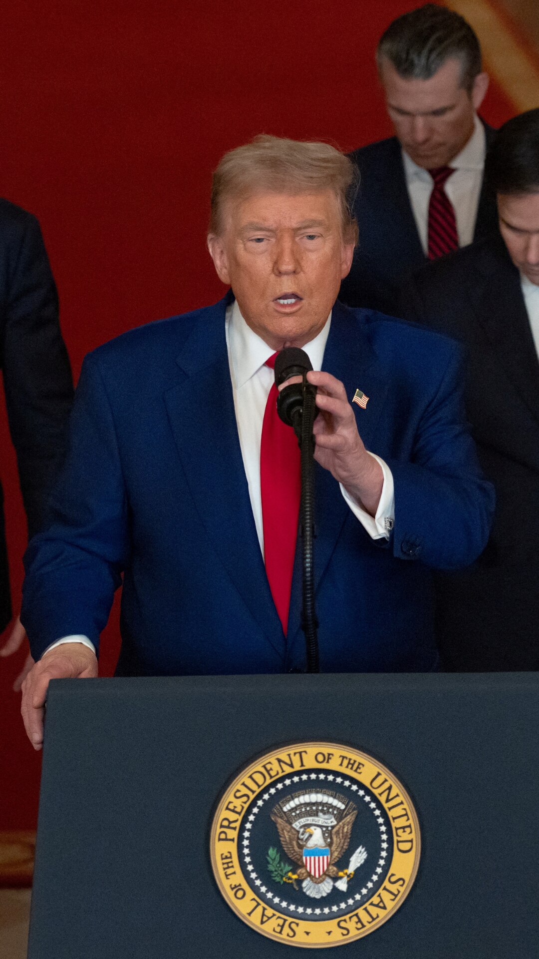 US President Donald Trump stands at a lecturn delivering a speech