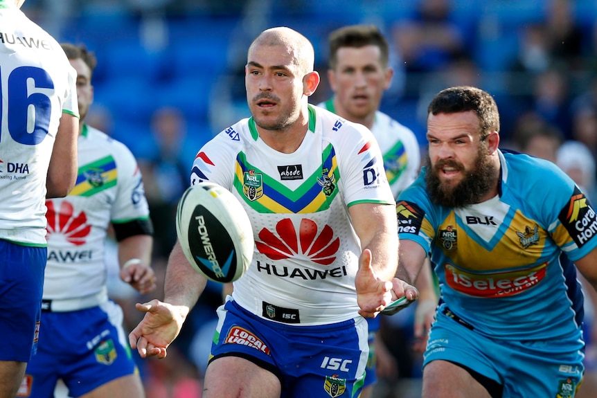 A man in sports clothes with other men in sport clothes chasing him