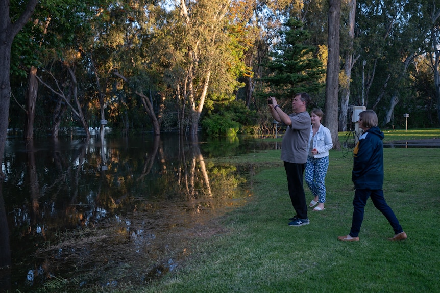 Un homme prend une photo de l'eau avec un téléphone