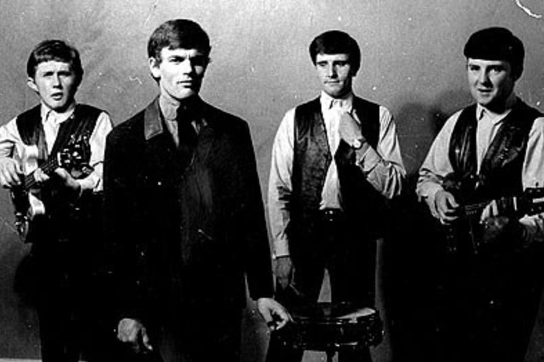 A black and white photo of a well dressed band of young men with instruments.