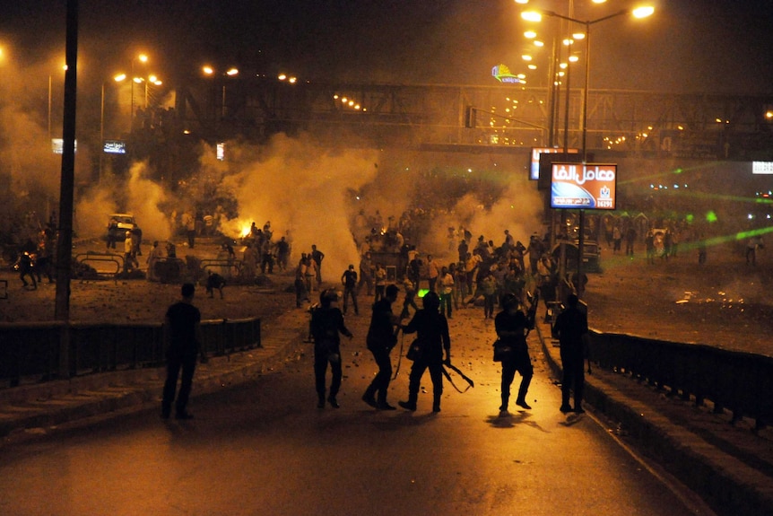 Supporters of the Mohamed Morsi (back) clash with riot police in Cairo in the early hours of July 27, 2013.