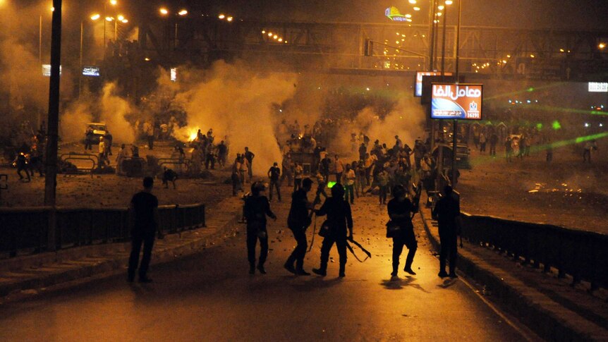 Supporters of the Mohamed Morsi (back) clash with riot police in Cairo in the early hours of July 27, 2013.