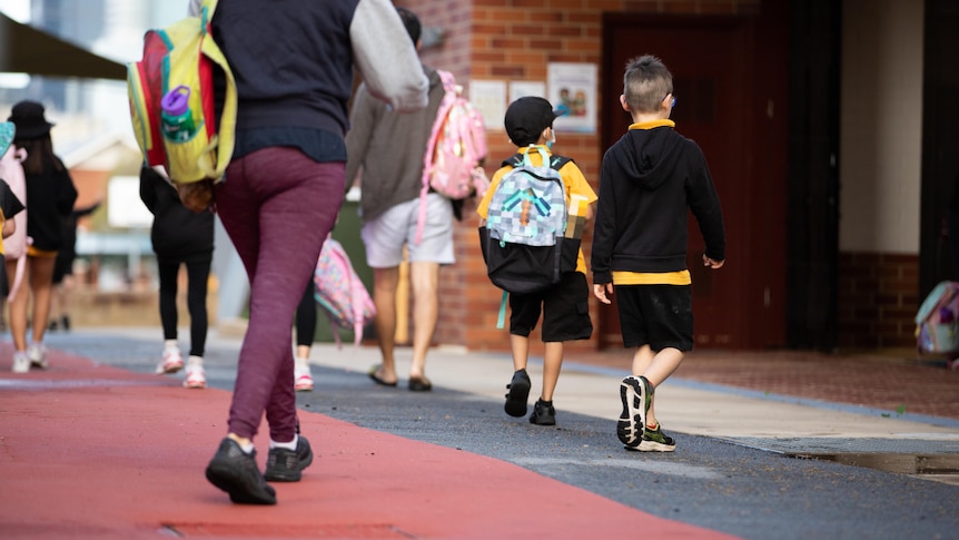 Small children walking in school to their classrooms.