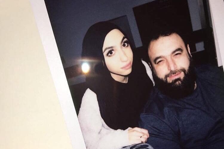 A photo of a Polaroid photograph with Ella posing next to her father with her hand on his shoulder.  