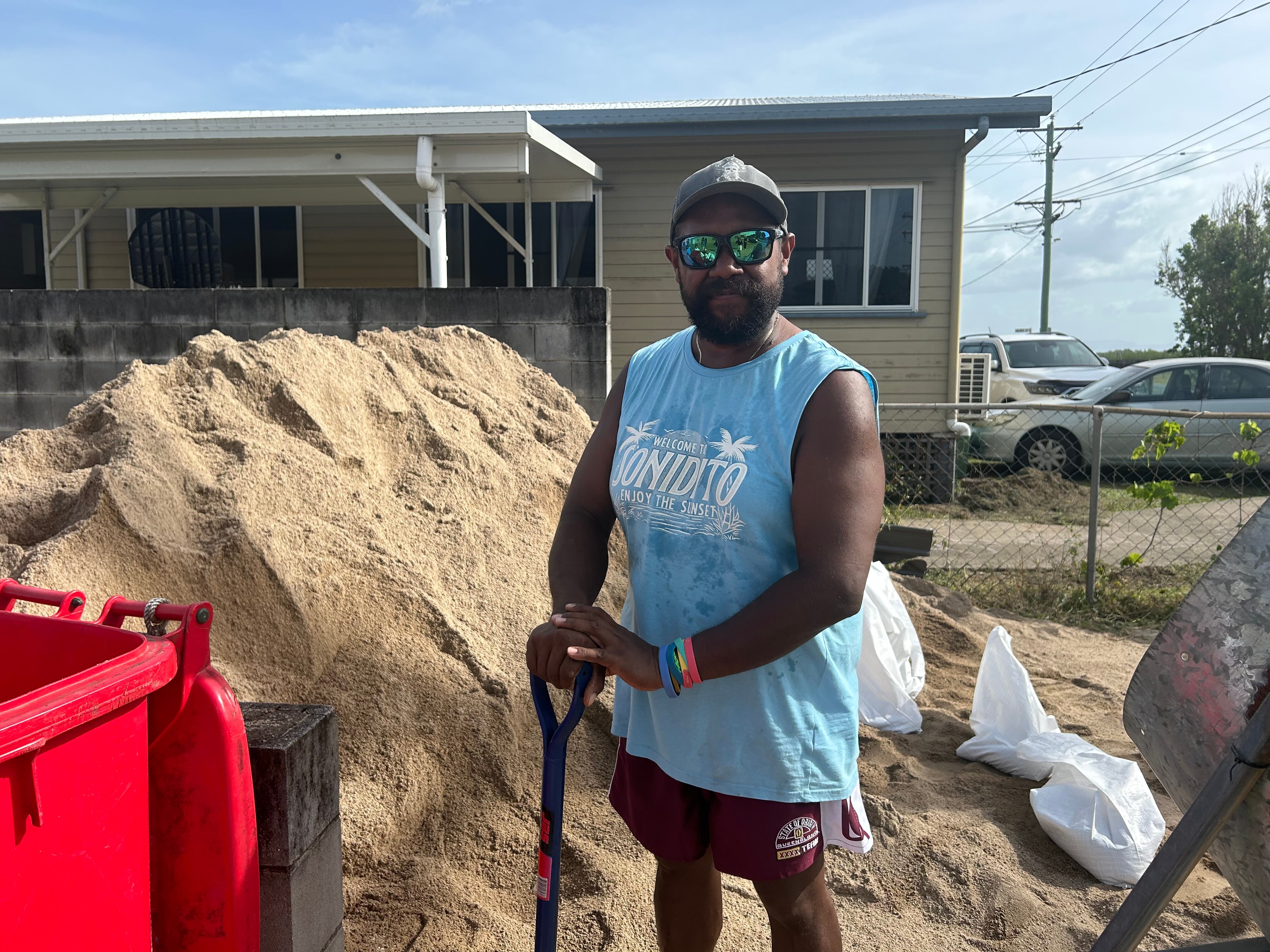 a man with a shovel in front of a pile of sand