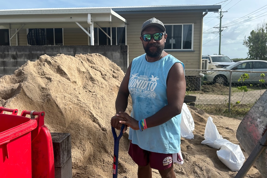 a man with a shovel in front of a pile of sand