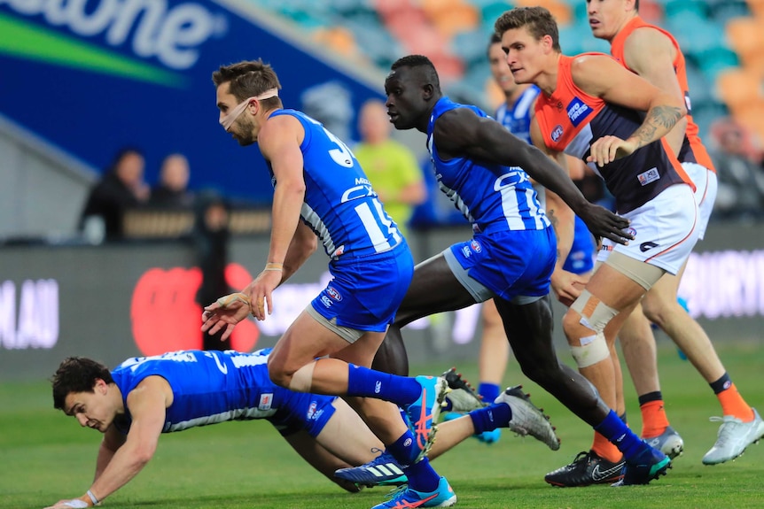 Jamie MacMillan of the Kangaroos is taped up during the Round 9 AFL match against GWS in Hobart.