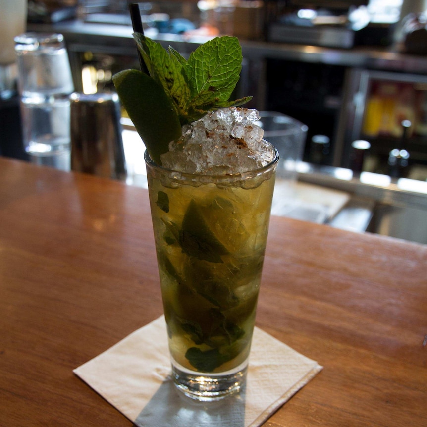 A glass filled with lime wedges, soft drink, juice and  ice.