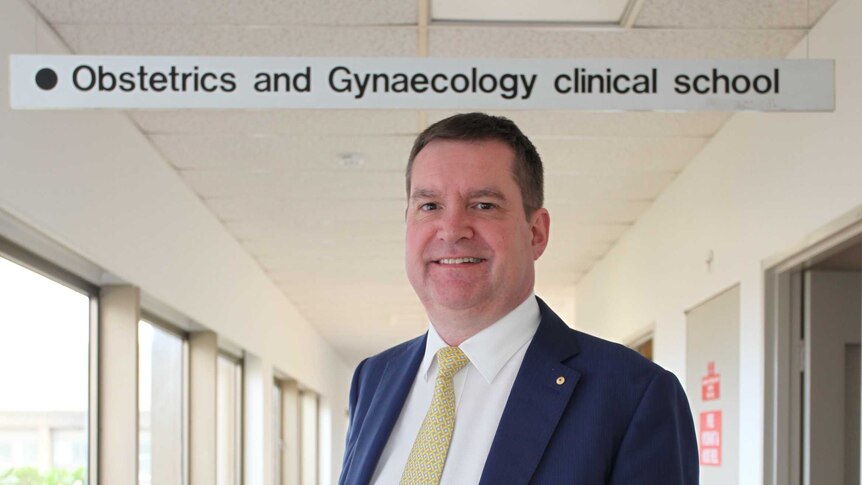 Obstetrician, Professor Euan Wallace stands in the hallway of Monash School of Obstetrics and Gynaecology