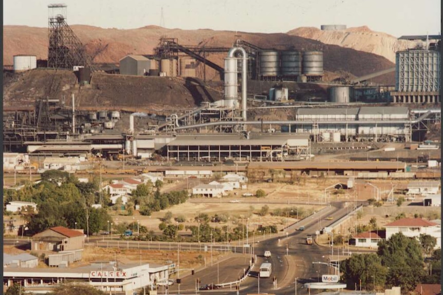 A large mine sits in the background while a Shell service station and urban roads are depicted in the foreground. 
