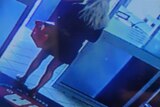 cctv of woman with basket walking out supermarket doors