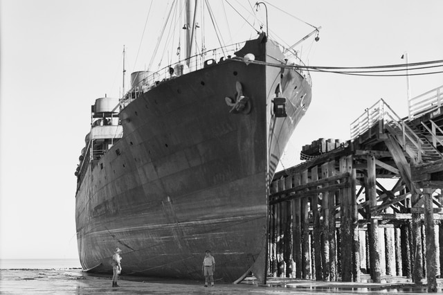 A black-and-white photo of the MV Koolinda docking in Broome after evacuating women and children from Darwin.