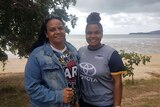 Aboriginal woman and teenage daughter standing on beach