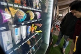 Students look at HIV testing kits in a vending machine.