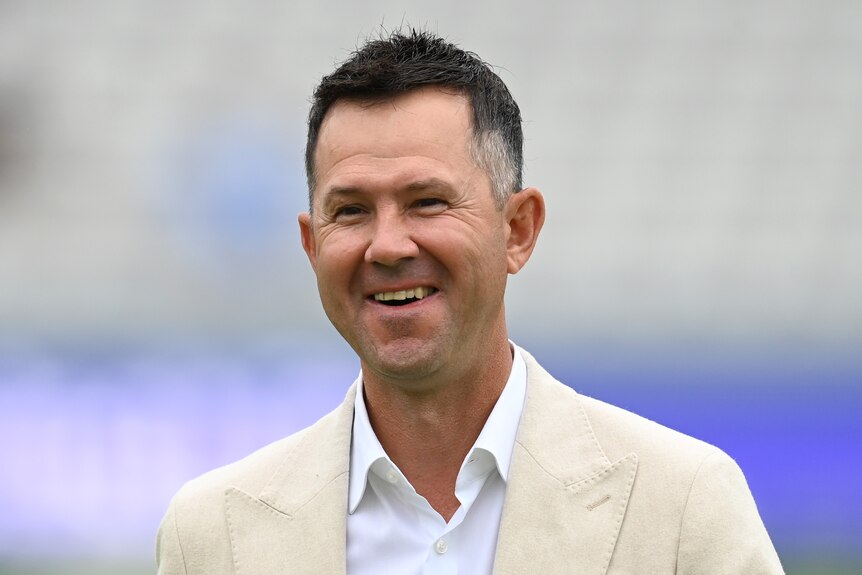 Australian cricket great Ricky Ponting smiles as he stands wearing a suit at jacket on the ground at Lord's. 
