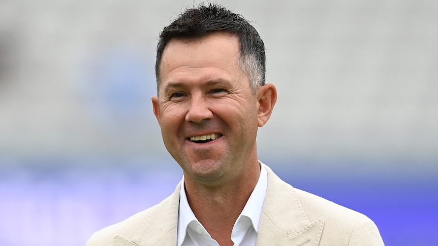 Australian cricket great Ricky Ponting smiles as he stands wearing a suit at jacket on the ground at Lord's. 
