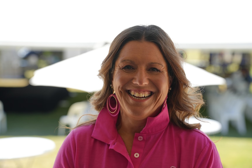 a woman in a pink shirt with brown hair