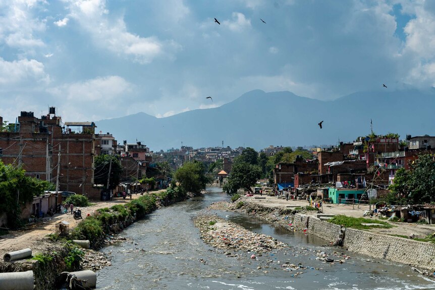 A river surrounded by rundown homes in Kathmandu.