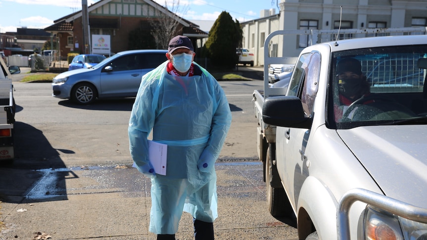 A man in medical clothing at a COVID testing site