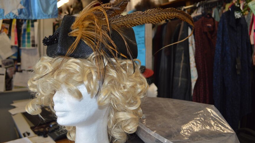 A brown feather hat is displayed among hundreds in the hat collection.