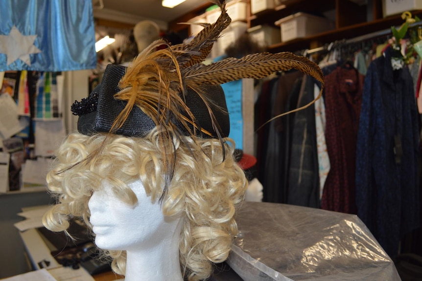 A brown feather hat is displayed among hundreds in the hat collection.