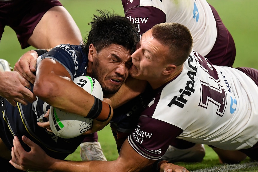 Dos hombres chocan cerca de la línea de prueba en un partido de la liga de rugby