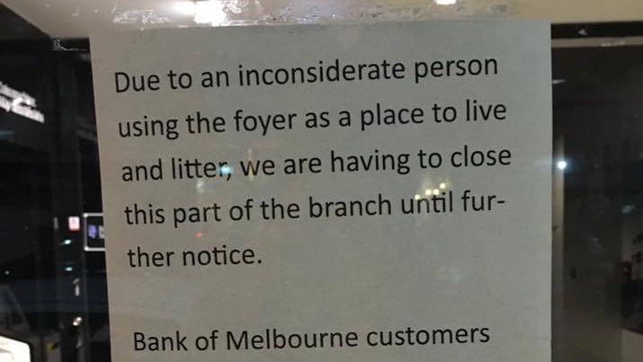 A photo of the sign about an "inconsiderate" homeless person stuck to the front window to Bank of Melbourne's Footscray branch.