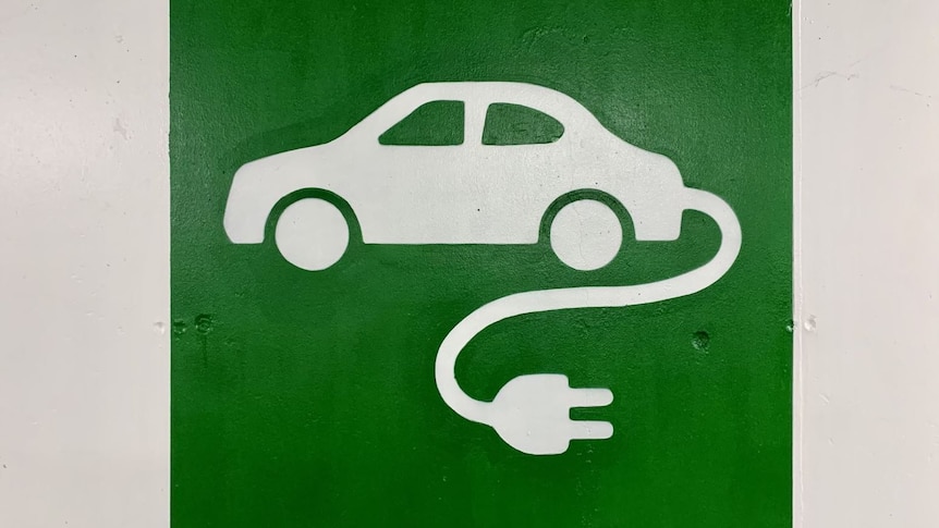 A sign showing a car with an electrical cord coming out of it.