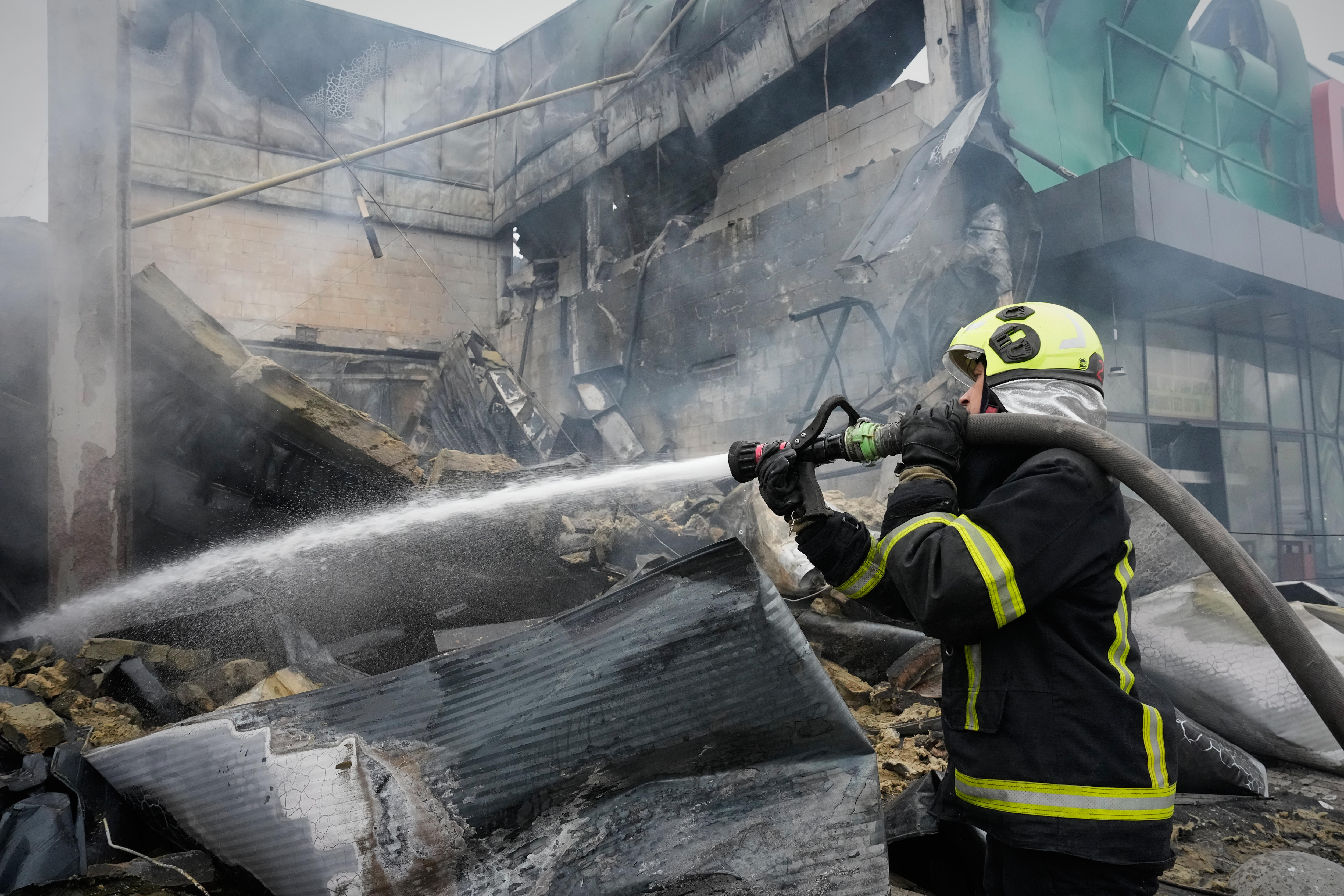 firefighter hoses down building destroyed by missile