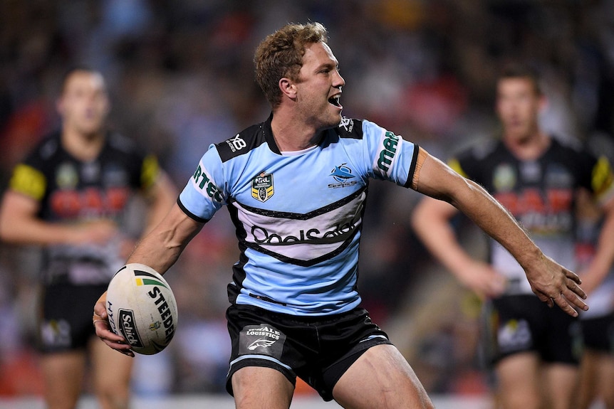 Matt Moylan prepares to throw the ball in the air after scoring a try for the Sharks against the Panthers.