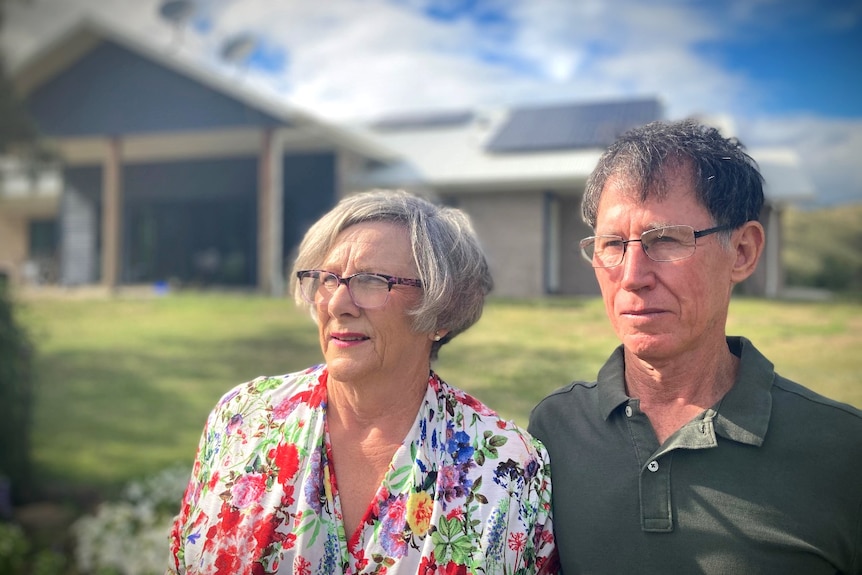 Helen and Bruce Norris standing in front of their new home with solar panels