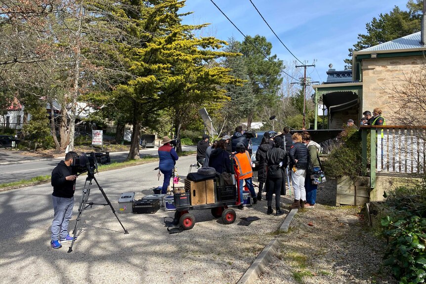 A film crew with cameras shooting near buildings.